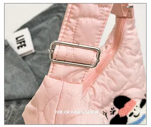 Detail of pink quilted nylon bag featuring heart stitching and a cute mouse patch