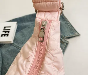 Detail of pink heart-quilted nylon fabric with smooth silver metal zipper and puller