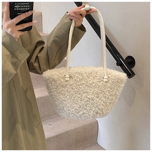 Detail of white fluffy lamb wool tote bag featuring soft fleece texture and leather strap