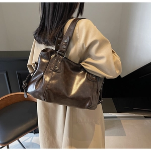 Détail du sac cabas vintage marron avec clous métalliques argentés et texture huilée