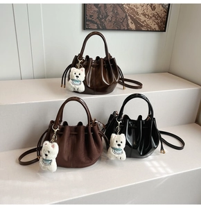 Vue détaillée de sacs seaux vintage en café, marron et noir avec des breloques en peluche