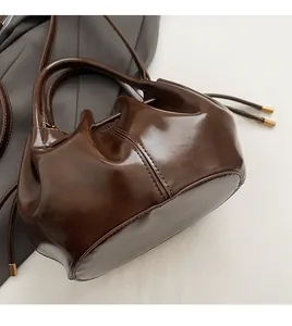 Détail du sac seau vintage marron foncé avec texture cirée et fermeture à cordon