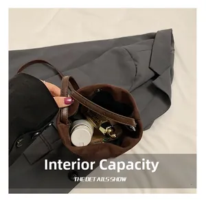 Interior capacity detail of the brown suede bucket bag with magnetic closure and skincare items
