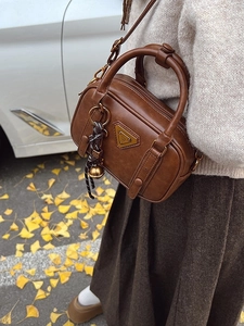 Vintage brown leather Boston handbag with gold metal triangle plaque and bell charm