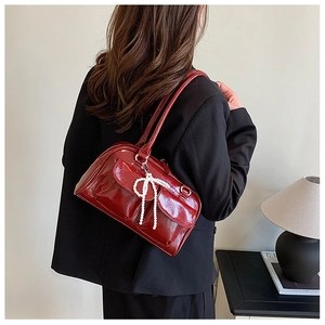 Sac Boston en cuir verni bordeaux avec nœud en perles et poches avant à rabat