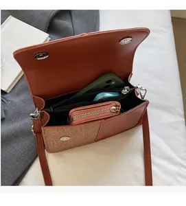 Vue intérieure d'un sac à main bicolore montrant sa capacité et sa poche zippée