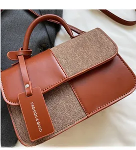Détail du sac à main vintage en cuir grainé et tissu texturé avec étiquette décorative