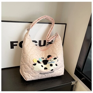 Detail of pink quilted nylon tote bag with heart patterns and naughty puppy patch