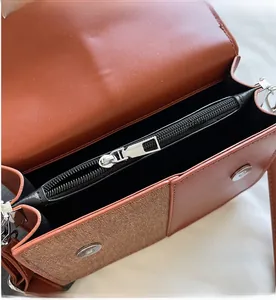 Détail du sac bandoulière en cuir PU marron avec fermeture éclair fluide et bouton aimanté