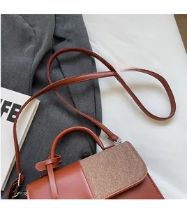 Détail du sac bandoulière vintage en cuir marron avec une longue bandoulière lisse