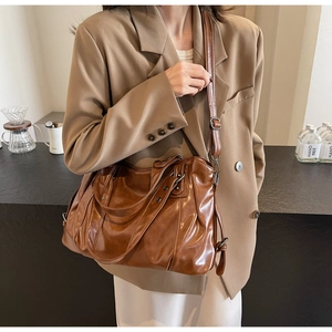 Sac fourre-tout en cuir marron avec texture plissée et bandoulière réglable en situation