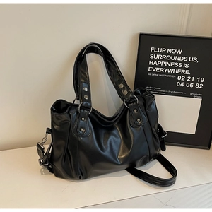 Détail d'un cabas noir en cuir PU avec rivets argentés et bandoulière réglable