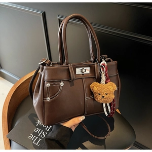 Close-up of vintage brown leather handbag with contrast stitching and silver turn-lock