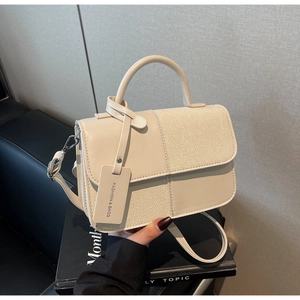 Détail du sac bandoulière en cuir crème et tweed avec poignée ronde et bandoulière amovible