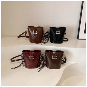 Détail de sacs seaux vintage en marron, noir et bordeaux avec des boucles métalliques