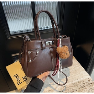 Detail of dark brown vintage handbag featuring contrast white stitching and silver twist lock