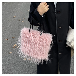 Détail du sac cabas en plumes roses avec fines anses en cuir noir et texture pelucheuse