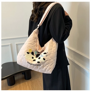 Detail of pink heart-quilted nylon tote with cartoon puppy embroidery and wide strap