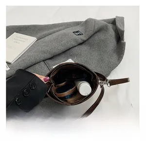 Vue intérieure montrant la capacité de rangement pour cosmétiques du sac en cuir marron