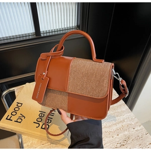 Détail du sac à main patchwork marron avec tissu texturé et plaque métallique de mode