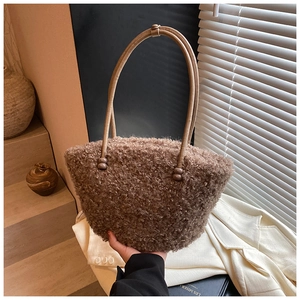 Detailed texture of brown fuzzy teddy fleece handbag with smooth leather shoulder straps