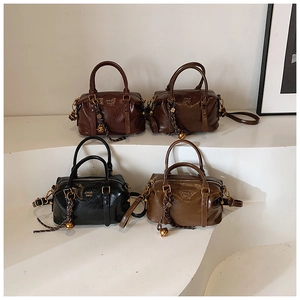 Detailed view of vintage Boston bags in oil wax leather with decorative bell charms