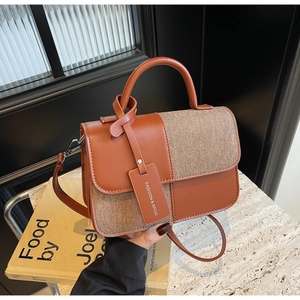 Gros plan détaillé d'un sac à bandoulière en similicuir marron et tissu beige croisé
