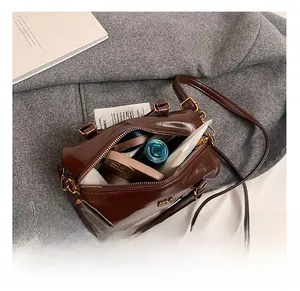 Interior capacity detail showing dark brown Boston bag with smartphone and makeup items