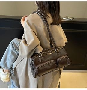 Detail view of the vintage brown wax leather shoulder bag with functional front zip pockets