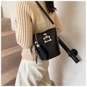 Détail du sac seau vintage noir avec breloque étoile argentée et bandoulière réglable