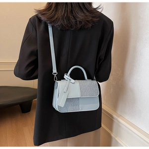 Détail du sac bandoulière bleu clair avec textures mixtes et bandoulière amovible