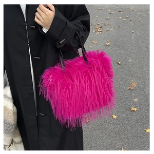 Détail d'un sac à main en fausse fourrure rose vif avec des poignées en cuir noir chic