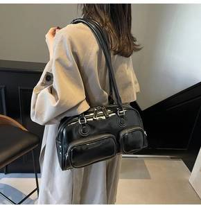 Detail view of black glossy patent leather bowling bag with side pockets and silver hardware