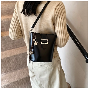 Détail du sac seau noir en cuir avec boucle argentée et breloque en étoile