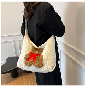 Detail of white quilted nylon tote bag with a 3D plush bear wearing a red scarf