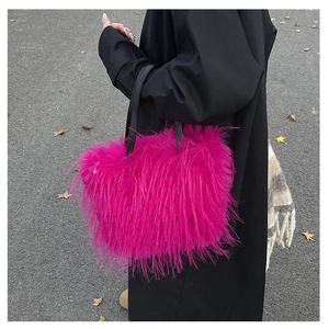 Détail d'un sac à main rose en fausse fourrure avec anses en cuir dans un décor d'automne