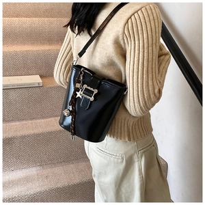 Détail du sac seau noir en cuir brillant avec pendentif étoile en métal argenté