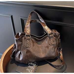 Détail d'un sac cabas marron vintage en similicuir avec rivets rétro sur chaise en bois