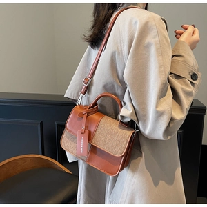 Détail du sac à main bicolore avec texture en cuir et finitions en tissu tissé chic