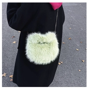 Dettaglio della borsa di peluche verde menta con morbida pelliccia e tracolla a catena d'argento