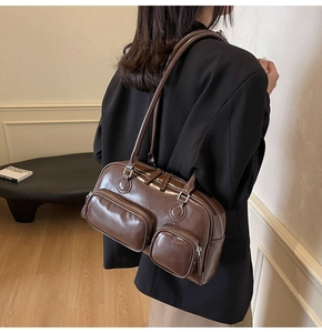 Detail view of a vintage dark brown leather shoulder bag with functional dual zip pockets