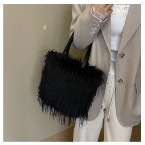 Vue détaillée du sac à main en fourrure noire porté avec une veste de blazer beige