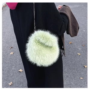 Dettaglio della borsa di peluche verde menta con elegante tracolla a catena in metallo
