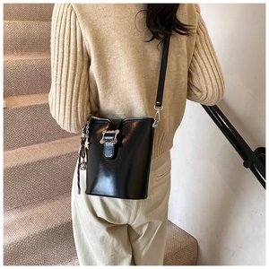 Détail du sac seau en similicuir noir avec boucle argentée et pendentif étoile