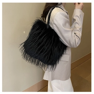 Gros plan du sac bandoulière en fausse fourrure noire porté avec un look minimaliste