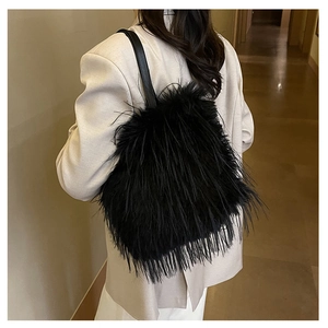 Gros plan d'un sac bandoulière en fausse fourrure noire avec sangle en cuir pour l'hiver