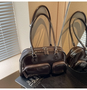 Detail of glossy deep brown wax leather bowling bag with functional front zipper pockets