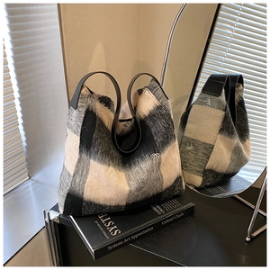 Detalle de bolso tote de lana a cuadros blanco y negro con bordado de lazos