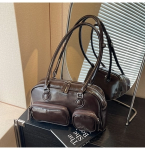 Detail of a dark coffee glossy bowling bag showing multiple pockets and retro silver zippers