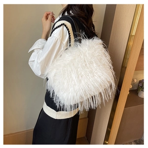 Vue latérale du sac à bandoulière en fausse fourrure blanche avec fines brides noires